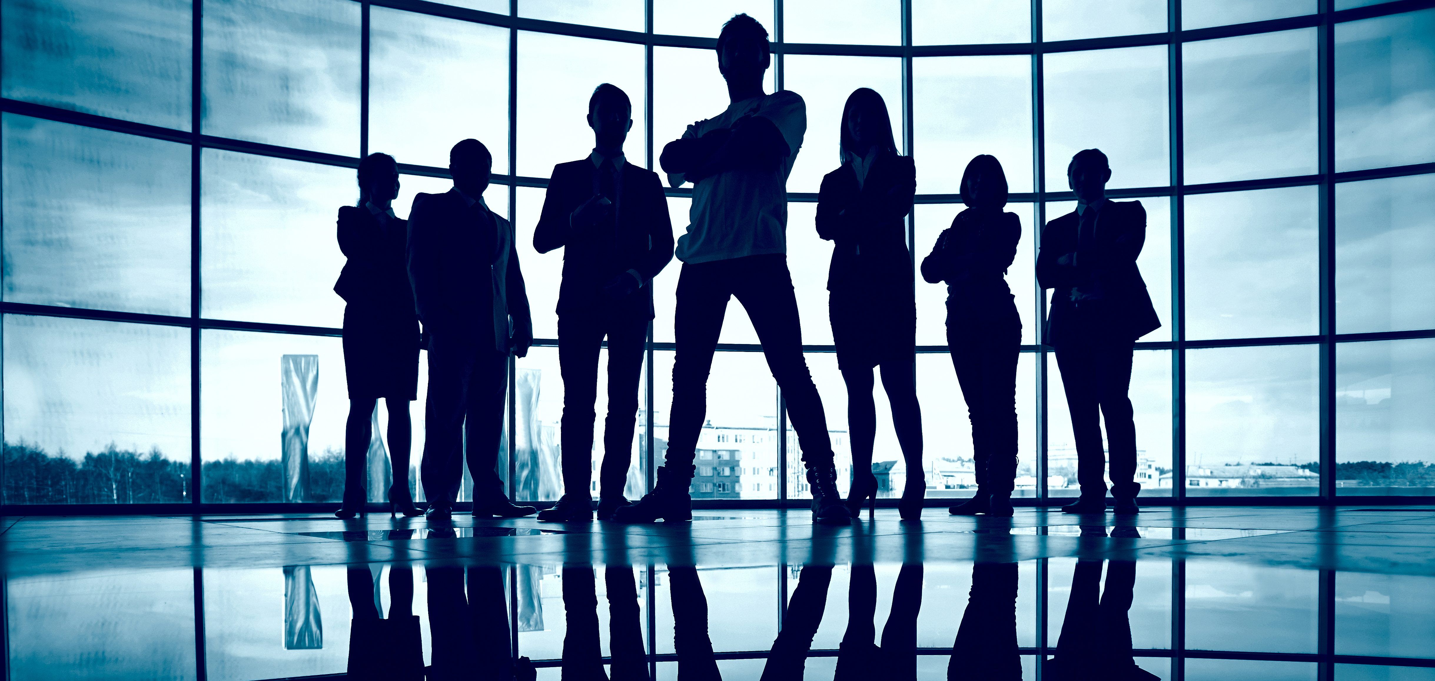 Business team Business team standing against window with leader in front